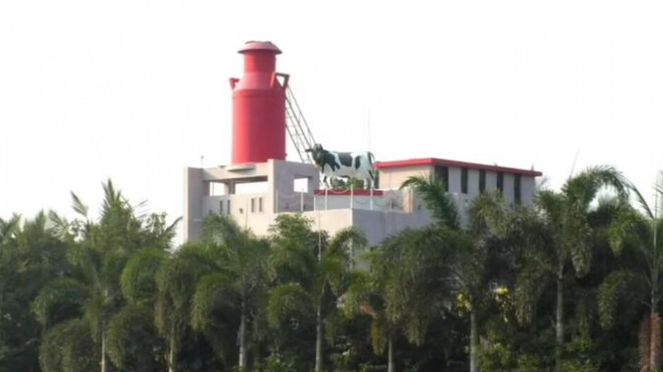 A statue of a cow and a milk churn stands tall over the bungalow