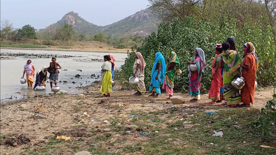 People collect drinking water from pond