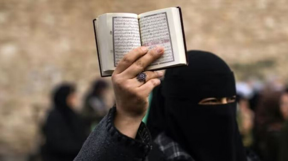Protester holds the Quran