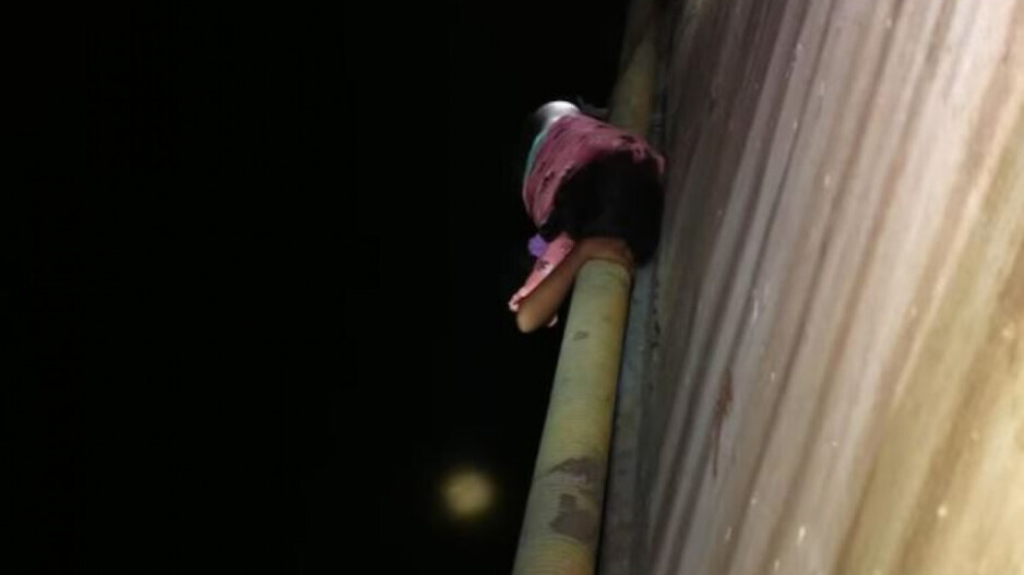 Keerthana hanging by a plastic pipe