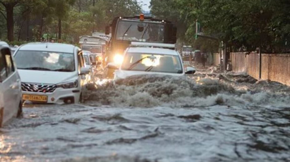 Vehicles wade through a waterlogged road amid rains