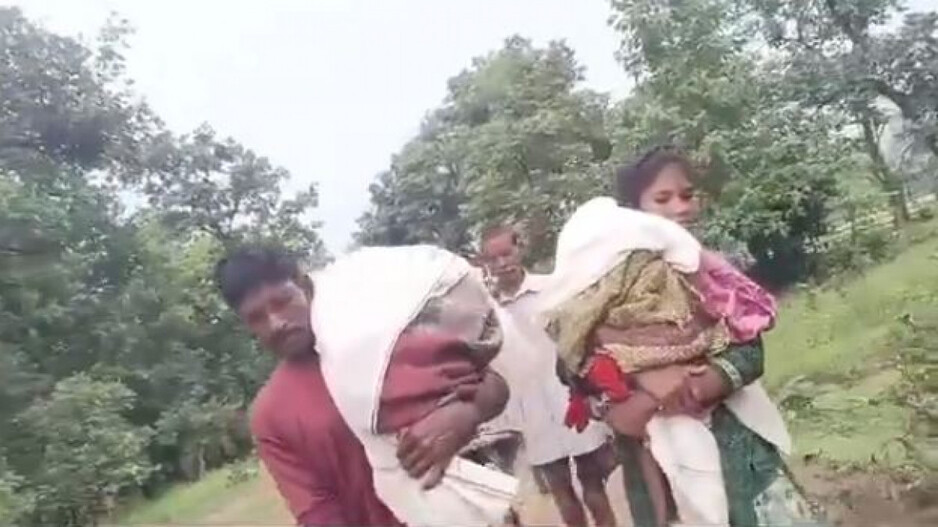 Couple carrying dead son 