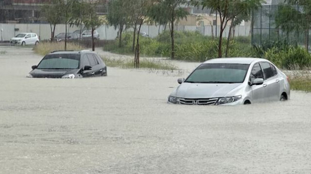 Cars drive through a flooded street during a rain storm in Dubai.