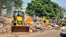 A bulldozer runs over the illegal house