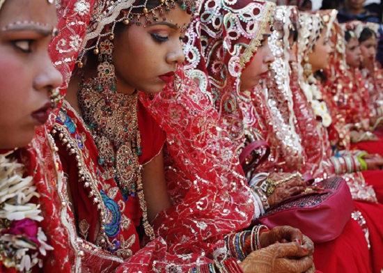 Brides sit as they wait to take their wedding vows during a mass wedding ceremony at a temple in New Delhi