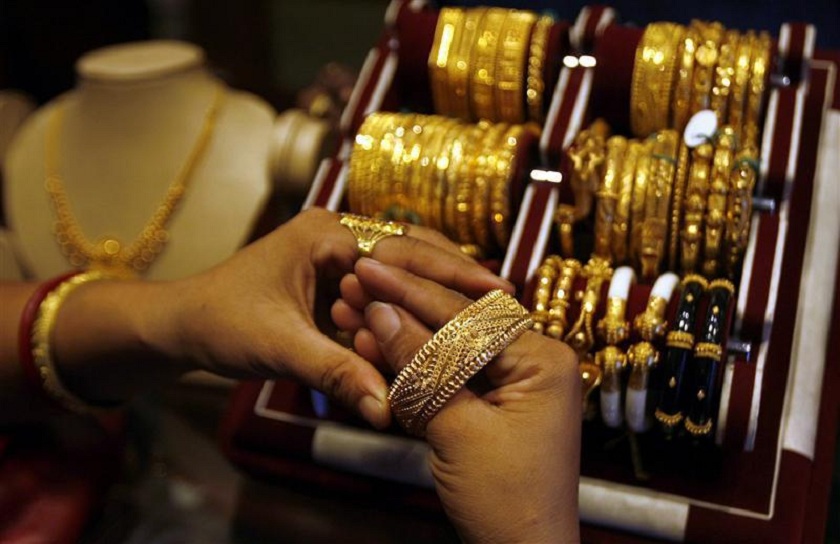 Woman wears gold bangle at jewellery shop in Siliguri
